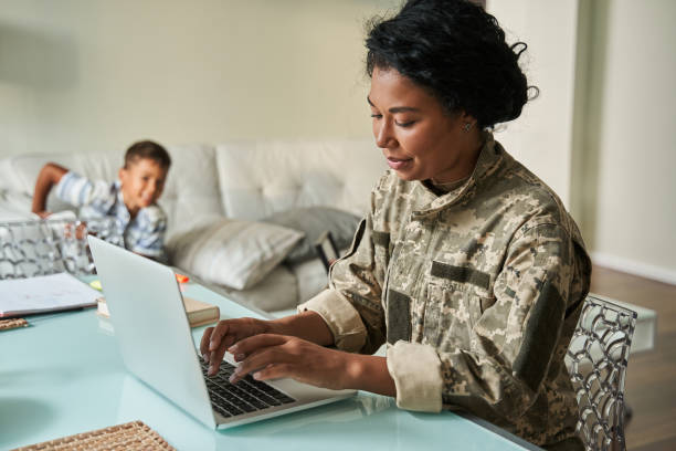 istock Black woman soldier using laptop at home 1341245628