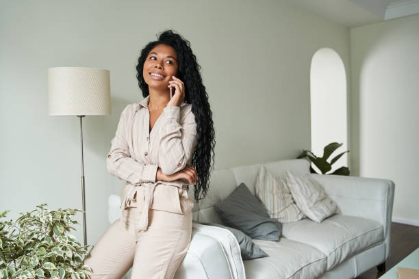 istock Smiling young black woman talking on mobile phone 1341245630