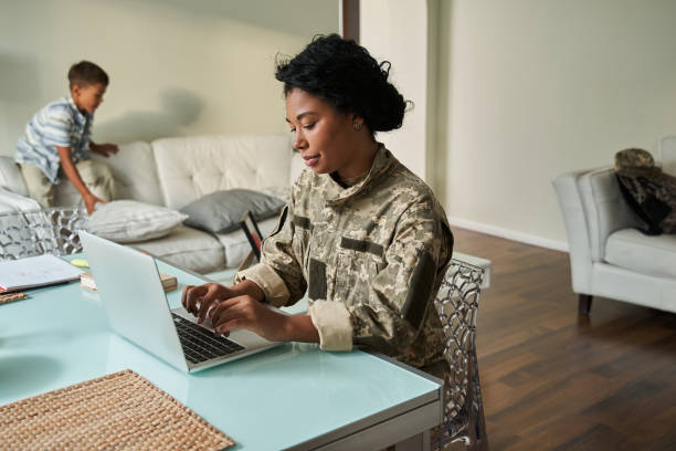 istock Black woman soldier using laptop at table 1341245636