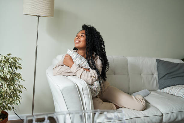 istock Multiracial brunette female embracing pillow and looking at the window 1341245671