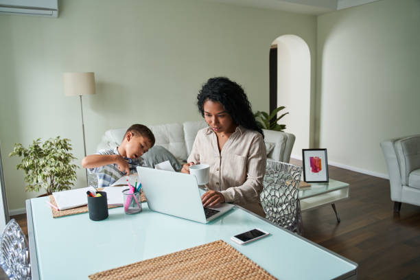 czarna matka korzystająca z laptopa i dziecięcego rzemiosła - multi ethnic group concentration mobile phone using laptop zdjęcia i obrazy z banku zdjęć