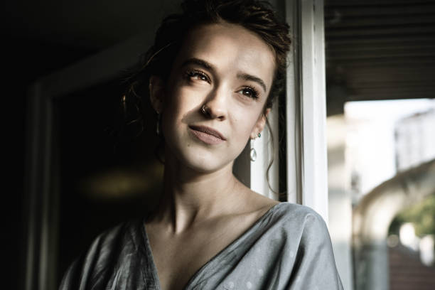 istock Beautiful young woman looking the window 1341247844