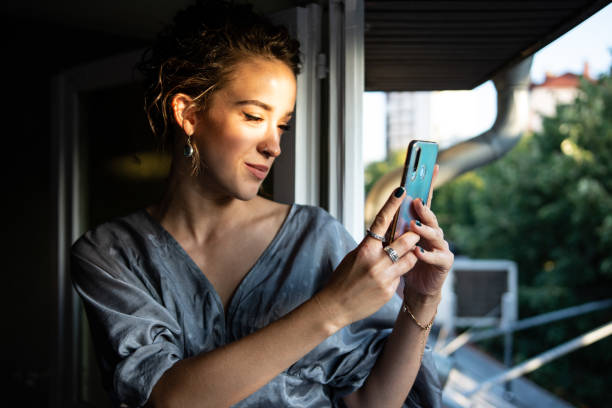 istock Beautiful young woman using smart phone at home 1341247859