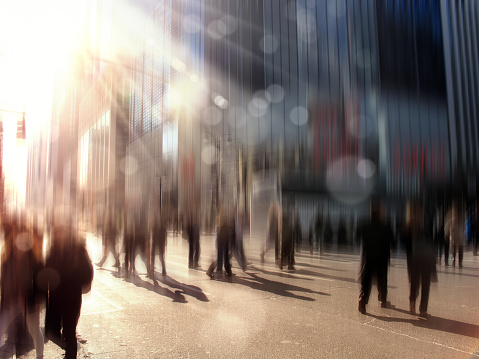 Blurry abstract image of Large group of people walking on crosswalk on busy street of Manhattan, New York