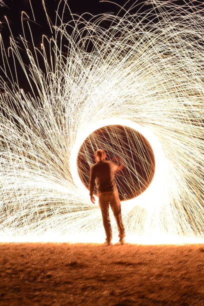 istock Iron wool circle drawing light fireworks. Burning Steel Wool spinning, Trajectories of burning sparks at night. Movement light effect, steel wool fire hoop. long exposure light painting, Pyrotechnic 1341251573