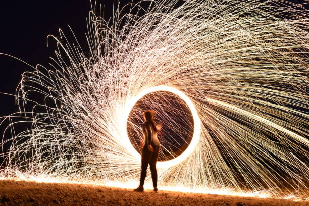 istock Iron wool circle drawing light fireworks. Burning Steel Wool spinning, Trajectories of burning sparks at night. Movement light effect, steel wool fire hoop. long exposure light painting, Pyrotechnic 1341251601