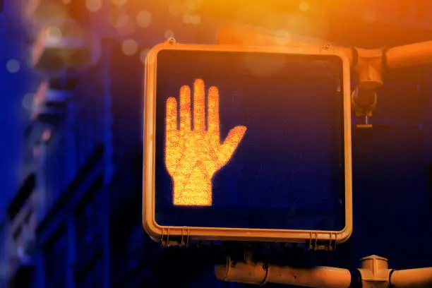 Photo of Close up traffic stop light for pedestrians in New York street