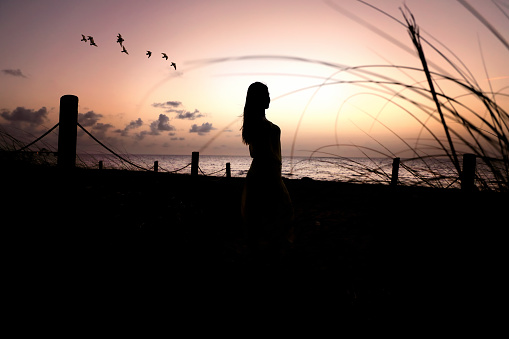 Silhouetted young woman at beach in Florida