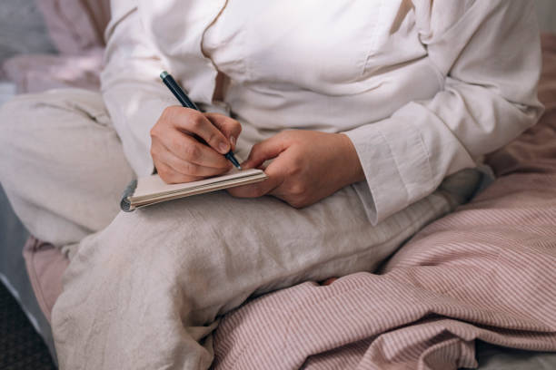 istock Anonymous Plus Size Woman Sitting on Her Bed and Writing 1341257550