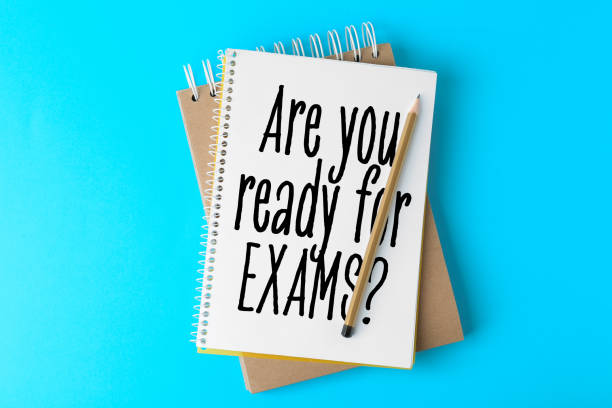 istock Notebooks with phrase ARE YOU READY FOR EXAMS and pencil on light blue background, top view 1341257681