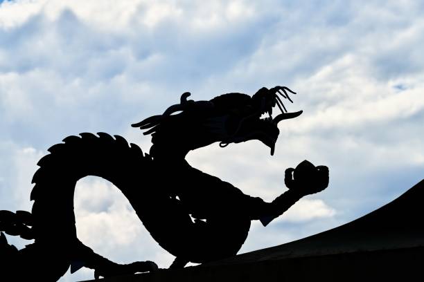 istock Silhouette of a dragon against a cloudy and blue sky 1341258890