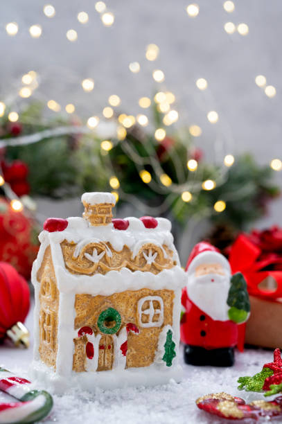 istock Gingerbread house with Christmas decorations, red baubles, fir branches, gift boxes and bokeh lights. 1341260008