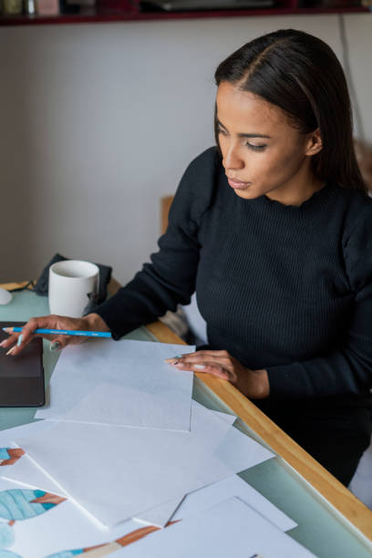 istock Young woman takes a design course using the videos posted by youtube, while isolated by the pandemic at home 1341260384