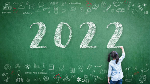2022 happy new year school class academic calendar with student kid's hand drawing greeting on teacher's green chalkboard for educational celebration, back to school, stem education classroom schedule - mundial 2022 imagens e fotografias de stock