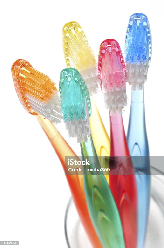 Toothbrushes Five multicolored toothbrushes in a glass on white background Bathroom Stock Photo