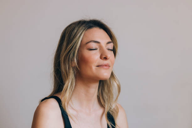 horizontal close up shot de uma linda mulher loira meditando com os olhos fechados - smiling serene people yoga women - fotografias e filmes do acervo