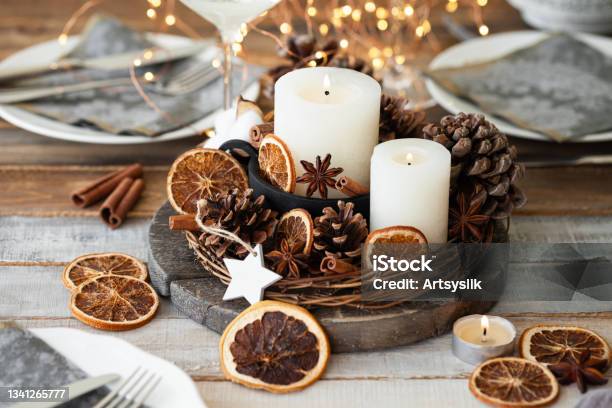Rustic Decor For Christmas Holiday Family Dinner Center Piece With White Candle Dry Orange Cones Cotton Zero Waste Eco Friendly Home Decoration Cozy Atmosphere Wooden Background Close Up Stock Photo - Download Image Now