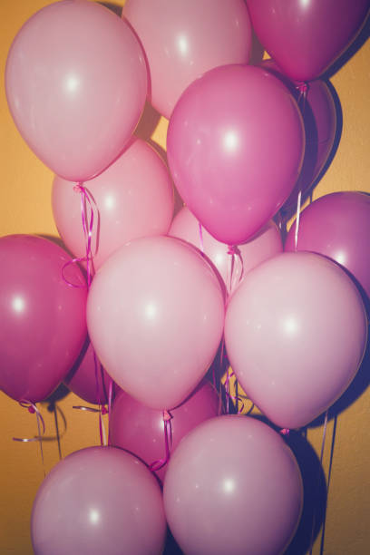 istock bunch of pink balloons on yellow background 1341266145