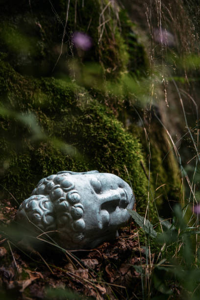 Otagi Nenbutsu-ji, Kyoto, Japan - November 21st, 2018: Detail shot of buddhist Stone Statues - Sculptures representing Rakan side by side in between autumn leaves close to Otagi Nenbutsu-ji Area, Arashiyama, Kyoto, Japan, East Asia, Asia.