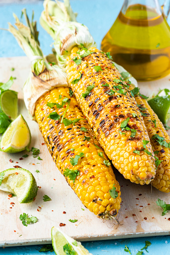 Roasted or Grilled Sweet Corn Cobs with Garlic, Coriander, Lime . Mexican Street Food. Top Down View.