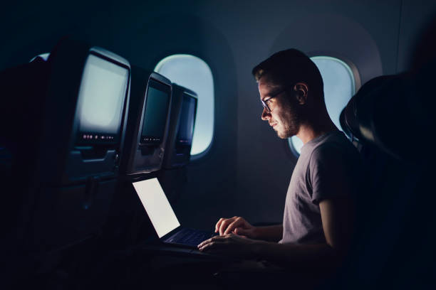 hombre usando computadora portátil en avión - airplane air vehicle business travel passenger fotografías e imágenes de stock