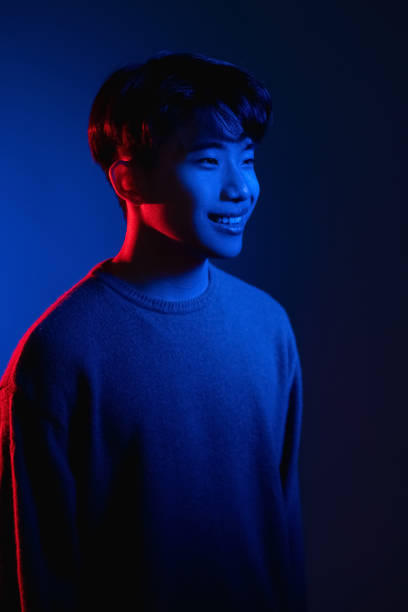 istock smiling asian man color light portrait neon blue 1341266400