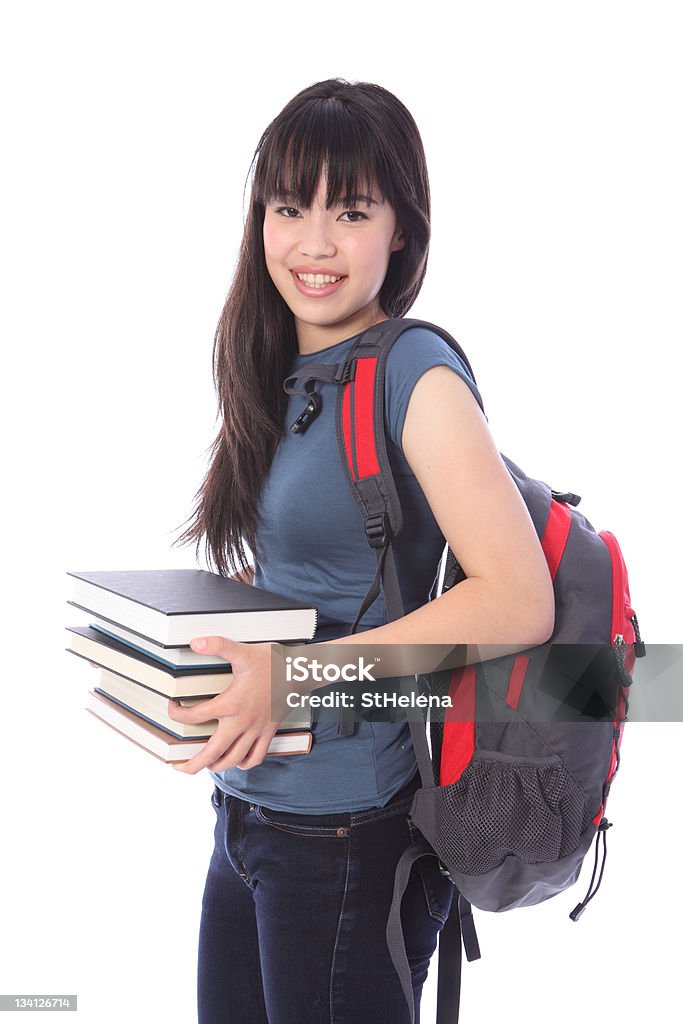 Ethnic college student girl with education books Carrying education books a beautiful smiling young Japanese teenager college student girl wearing blue denim jeans and t-shirt, backpack over her shoulder. Asian and Indian Ethnicities Stock Photo