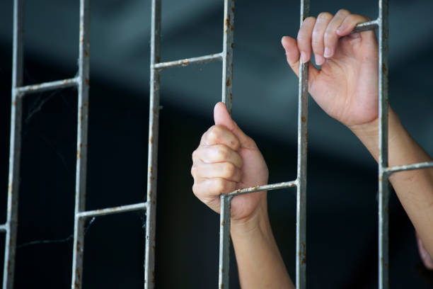 istock prisoner's hand arrest in jail 1341267144