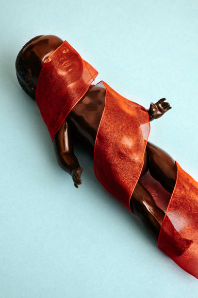istock black doll covered with a red ribbon lying on blue background 1341267777