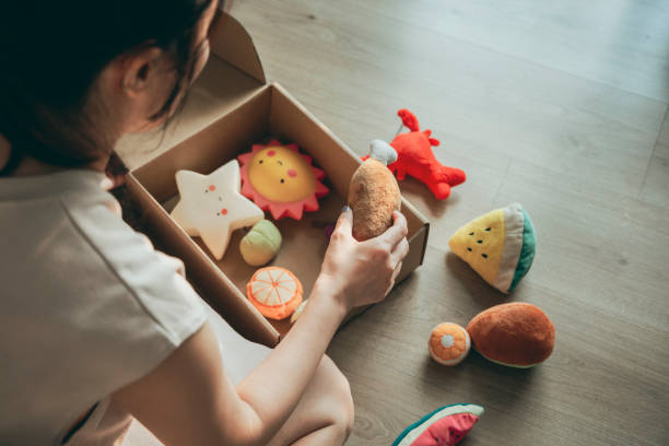 A mother donated toys Close up on carton donation box with children stuff, preparing clothing and toys for orphans needy kids. Kind female volunteer put things for poor families in charity package transparent donation box stock pictures, royalty-free photos & images