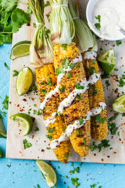 istock BBQ Grilled Whole Corn Cob. Served with HErbs, Lime and Salt on Wooden Board. Top View 1341268472
