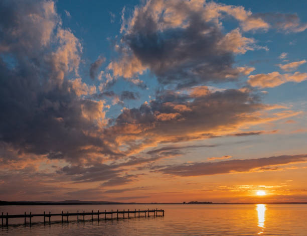 siluetta del molo con maestoso paesaggio nuvoloso al tramonto sul lago steinhuder meer, bassa sassonia, germania - steinhuder meer foto e immagini stock