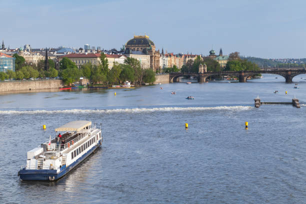 Charles Bridge and Prague Castle over Vltava River with barges and boats at sunset. Perfect end of one beautiful sunny day in Prague. Czech Republic.