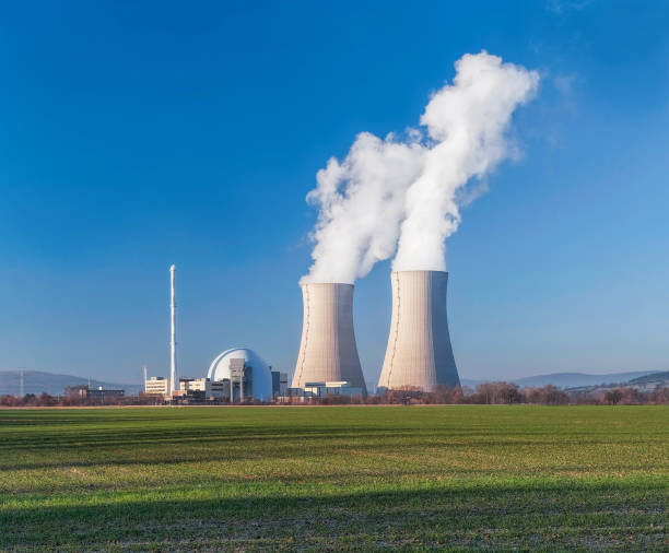 istock Nuclear power station with two white steaming cooling towers and clear blue sky 1341271666