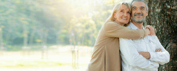 Active happy and enjoy love seniors couple embracing in autumn park stock photo