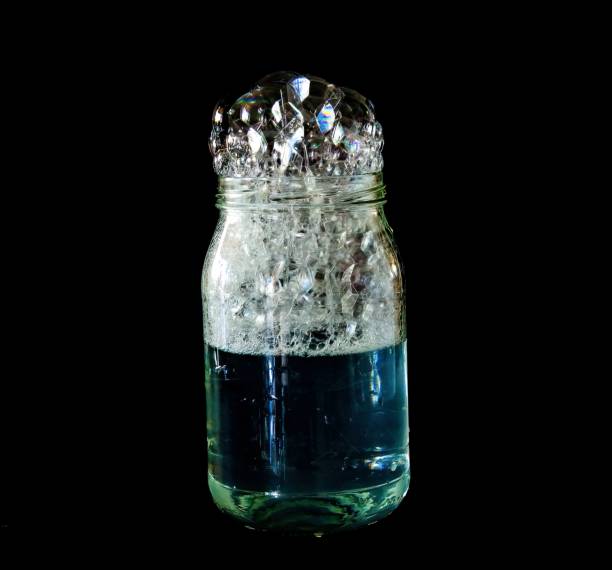 コップ一杯の水の中の石鹸泡 - overflowing water glass bottle ストックフォトと画像