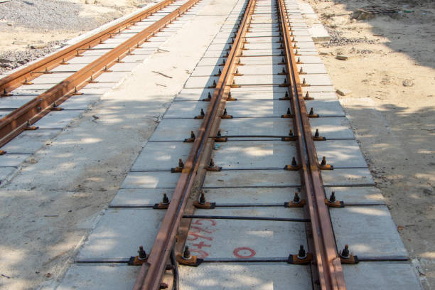 Repair of two-way tram tracks, laying of iron rails on reinforced concrete sleepers, the prospect of a repair site to the horizon Repair of two-way tram tracks, laying of iron rails on reinforced concrete sleepers, the prospect of a repair site to the horizon. railroad track concrete railway sleeper thoroughfare stock pictures, royalty-free photos & images