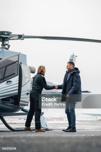 Chopper Pilot Greeting Man With Handshake Stock Photo - Download Image Now - Helicopter Pilot, Helicopter, Luxury