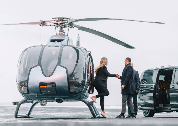 wealthy couple traveling by a private helicopter - helikopter stockfoto's en -beelden