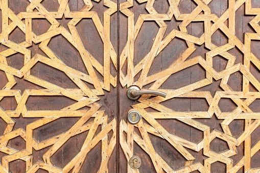 Fragment of old wooden door with decorative pattern. architectural textured background
