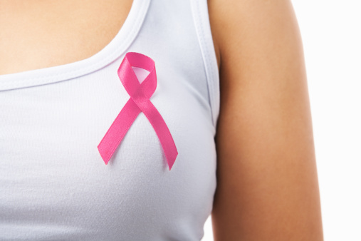 Close up of pink badge on woman chest to support breat cancer cause, PS: you can change the ribbon color to red to support AIDS cause as both using same symbol