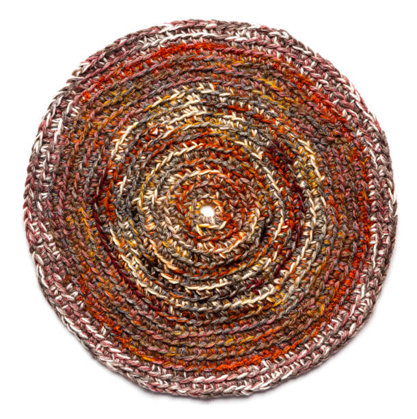 круглый коврик коричневого цвета, вязаный крючком из толстых нитей. изолирован на белом фоне - knitting vertical striped textile стоковые фото и изображения
