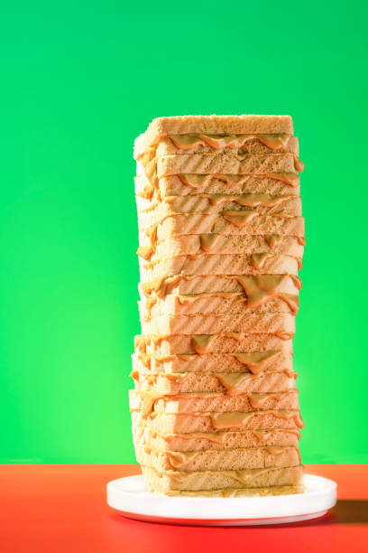 istock Peanut Butter Sandwich Tower. Bread Slices Stack on Colorful Background 1341282318