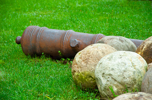old stone cannonballs and cannon barrel