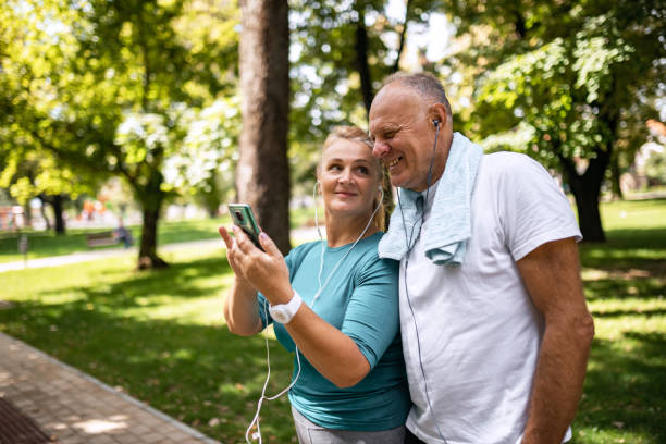 istock Senior couple using smart phone in public park before jogging 1341282377