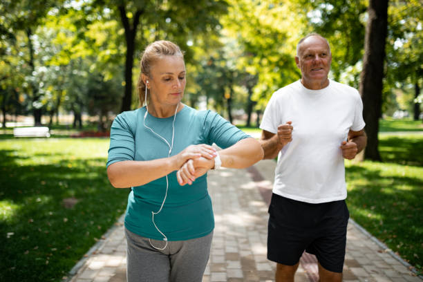 istock Mature woman checking a pulse on a smart watch while running with her husband 1341283461