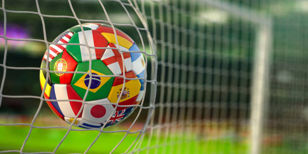 Football ball with flags of world countries in the net of goal of football stadium. World cup championship 2022. stock photo