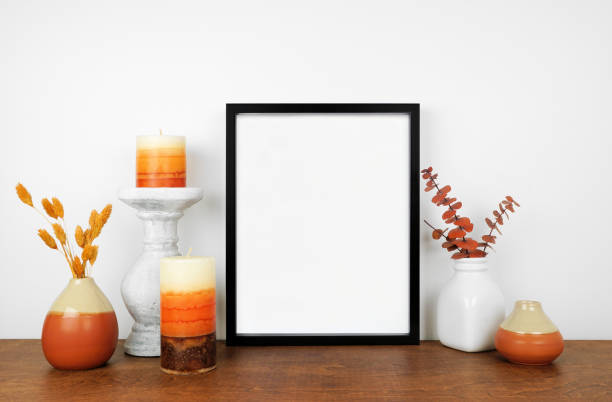 istock Mock up black frame with fall branches and decor on a wood shelf 1341286949