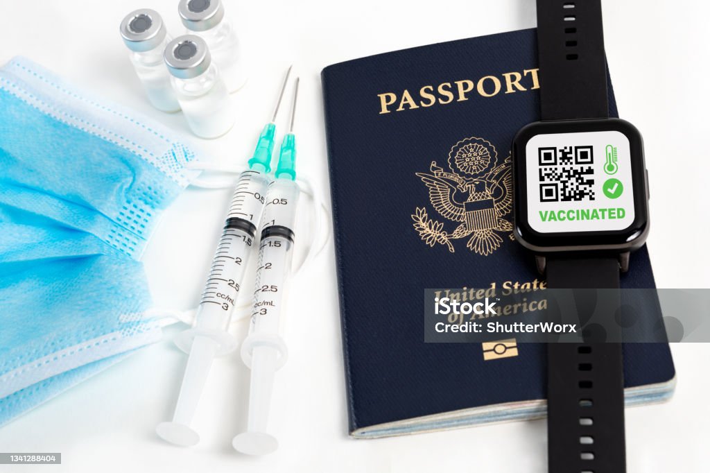 Covid-19 Travel Requirements Protective Face Mask, Covid-19 Vaccine Ampoules, Syringes With Needles, Smart Watch, And USA Passport Ampoule Stock Photo