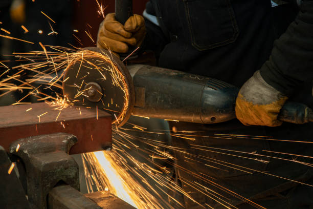 istock Worker man working with electric grinder tool on steel structure in factory. 1341289275